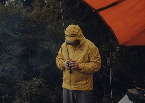 mann-in-regenjacke-mit-regenschirm